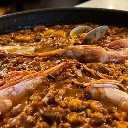 Primer pla d’una preparació daurada amb peces de diferents formes en un recipient negre