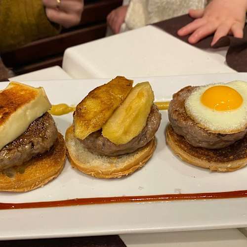 Tres petites preparacions rodones sobre un plat rectangular blanc